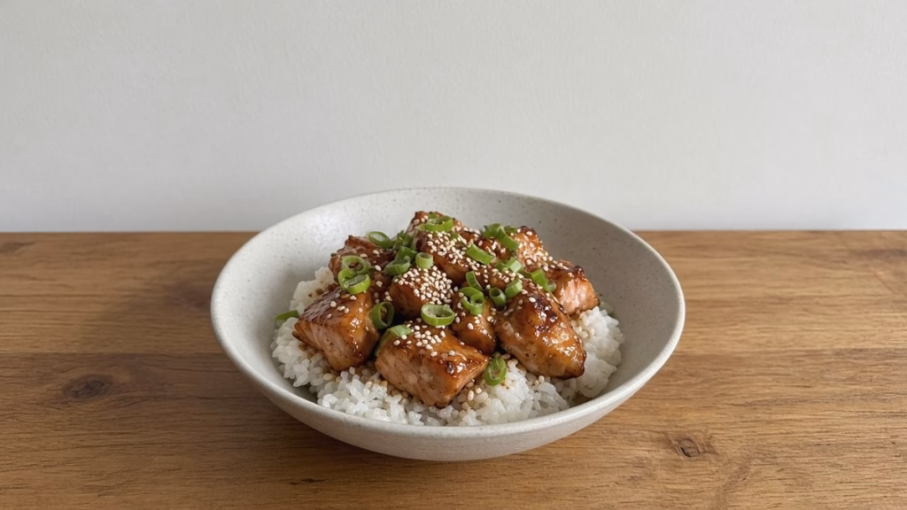 Honey soy air fryer salmon bites over rice with sesame seeds and green onion