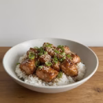 Honey soy air fryer salmon bites over rice with sesame seeds and green onion