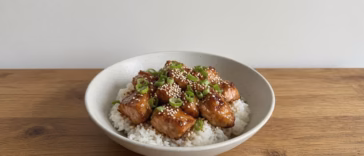 Honey soy air fryer salmon bites over rice with sesame seeds and green onion