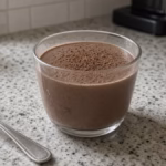 Smooth chocolate cottage cheese protein pudding in a small glass cup