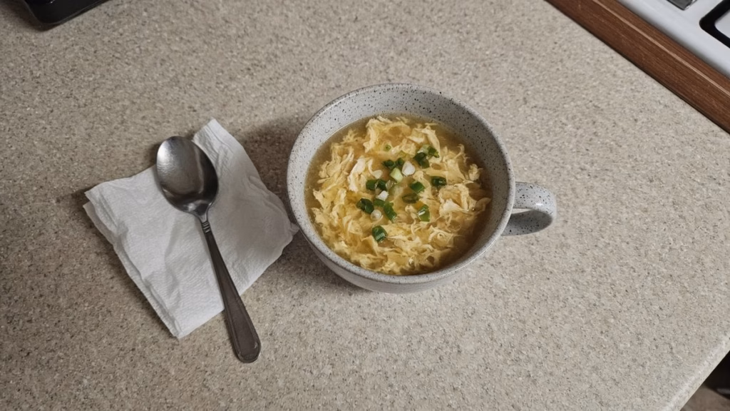 Mug of egg drop broth with green onion