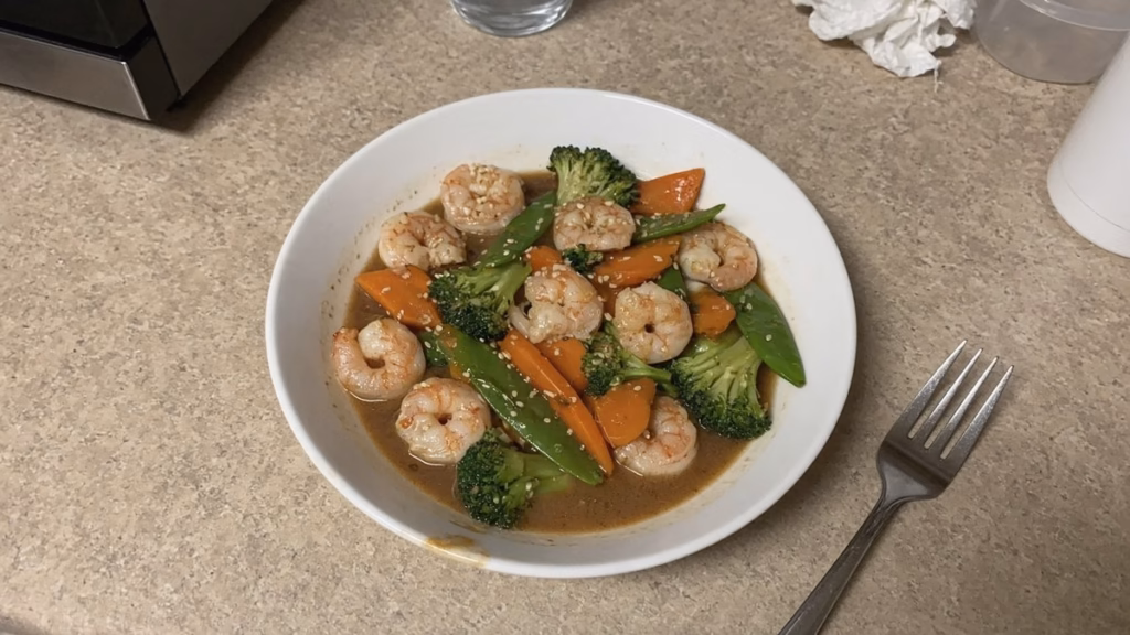 Bowl of mild shrimp stir-fry with broccoli, carrots and snow peas