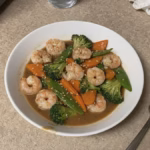 Bowl of mild shrimp stir-fry with broccoli, carrots and snow peas